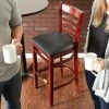 Lancaster Table & Seating Mahogany Ladder Back Bar Height Chair With Black Padded Seat