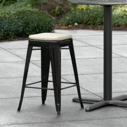 LT&S Alloy Series Lancaster Table & Seating Alloy Series Black Stackable Metal Indoor / Outdoor Industrial Cafe Counter Height Stool With Tan Fabric Magnetic Cushion