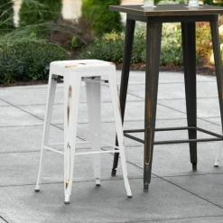 LT&S Alloy Series Lancaster Table & Seating Alloy Series Distressed White Stackable Metal Indoor / Outdoor Industrial Barstool With Drain Hole Seat