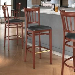 LT&S Spartan Series Lancaster Table & Seating Spartan Series Bar Height Metal Slat Back Chair With Mahogany Wood Grain Finish And Black Vinyl Seat